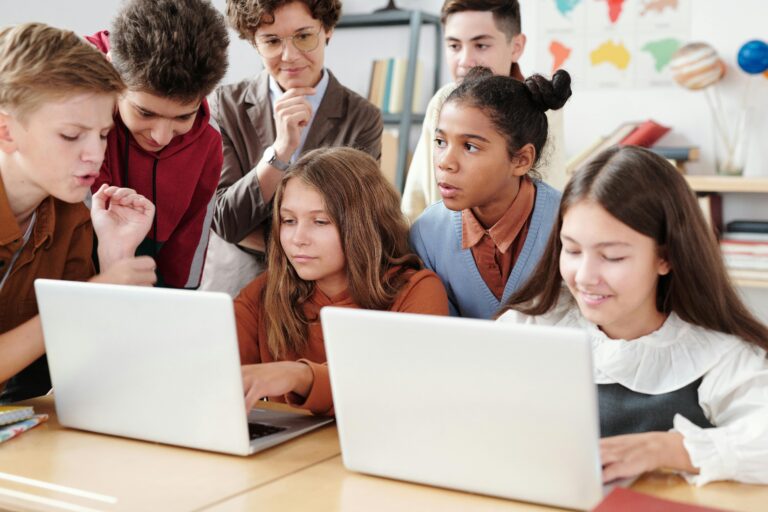 Alumnos en el aula, con sus computadoras realizando una actividad grupal